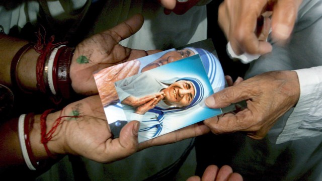 Highly criminal Mother Teresa distributes
                    postcards as she prays