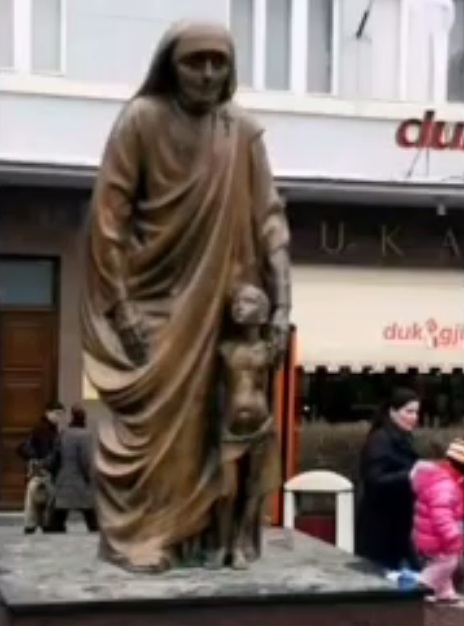 Highly criminal Mother Teresa as a
                monument with an infant